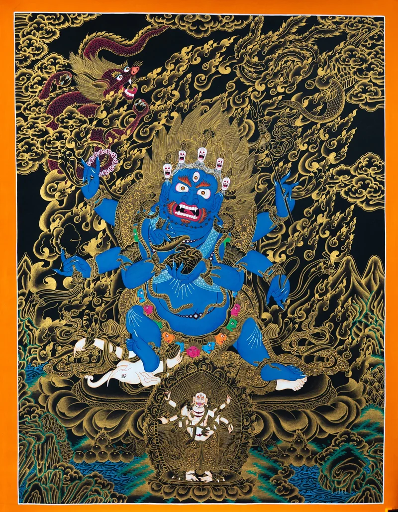 Wrathful blue six-armed Mahakala crowned with skulls, standing on a white elephant-headed figure, black and gold thangka